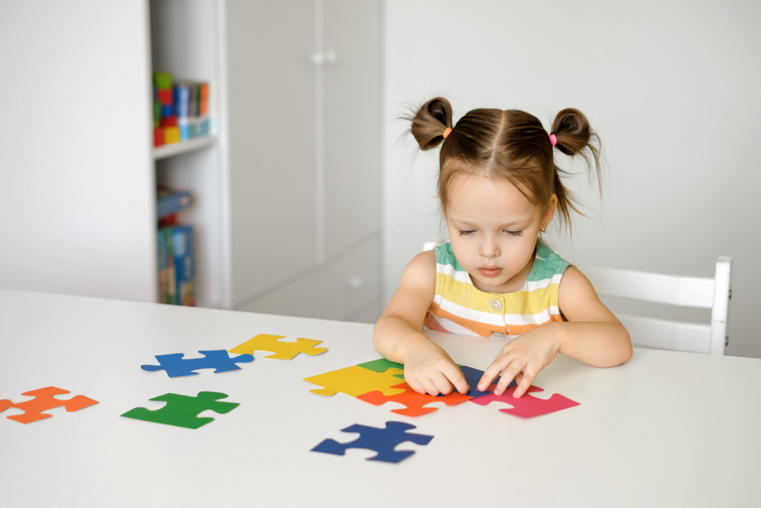 twoyearold-girl-collects-puzzles-sitting-table-nursery